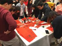 The participants of 'CWCNY—Gather And Share' writing <i>fai chun</i> to celebrate the Lunar New Year